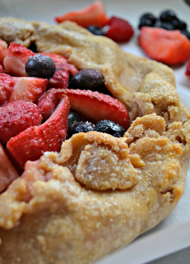 Wild Berry Tart recipe, a mix of fresh and sweetened raspberries, blueberries, and strawberries enveloped in a pie crust.